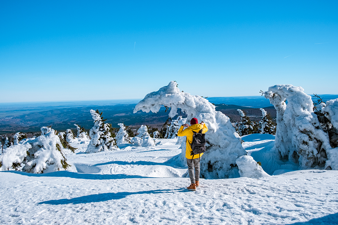 Wanderer auf Schnee-Gipfel im Harzgebirge mit Ausblick