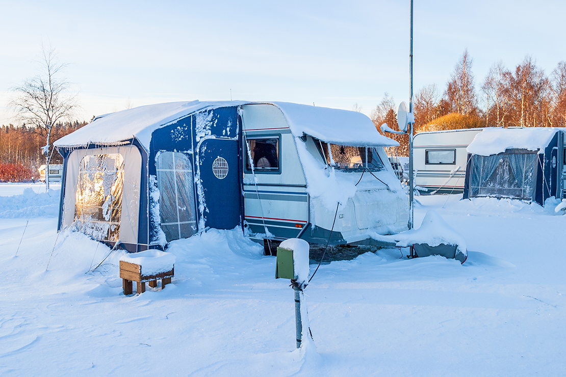 So geht Wintercamping: Camper steht auf Stellplatz im Schnee 